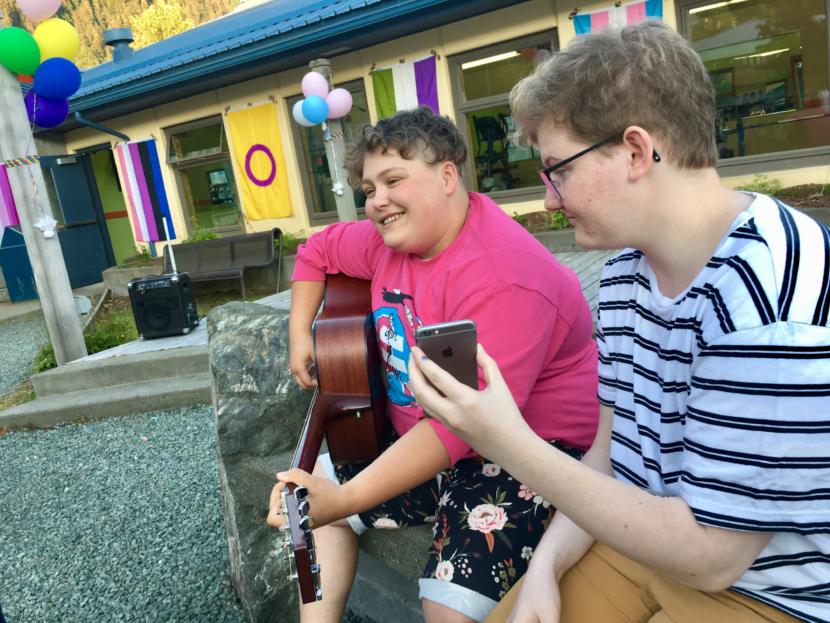 Callum Marks (right) serves as a "modern day page turner" for Theo Houck, who played a set of queer love songs at Juneau's first youth Pride party on June 20, 2019. (Photo by Zoe Grueskin/KTOO)