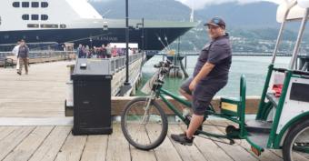 Theo Houck looks for pedicab passengers as Volendam passengers disembark in downtown Juneau on July 12, 2019. Houck had taken 6 days off because air quality had gotten unhealthy and he asthma-like symptoms.