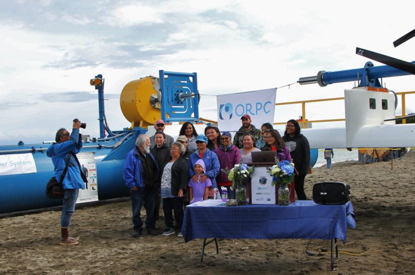 Residents of Igiugig pose in front of the RivGen system at the launch ceremony, July 16, 2019. (Photo by Isabelle Ross/KDLG)