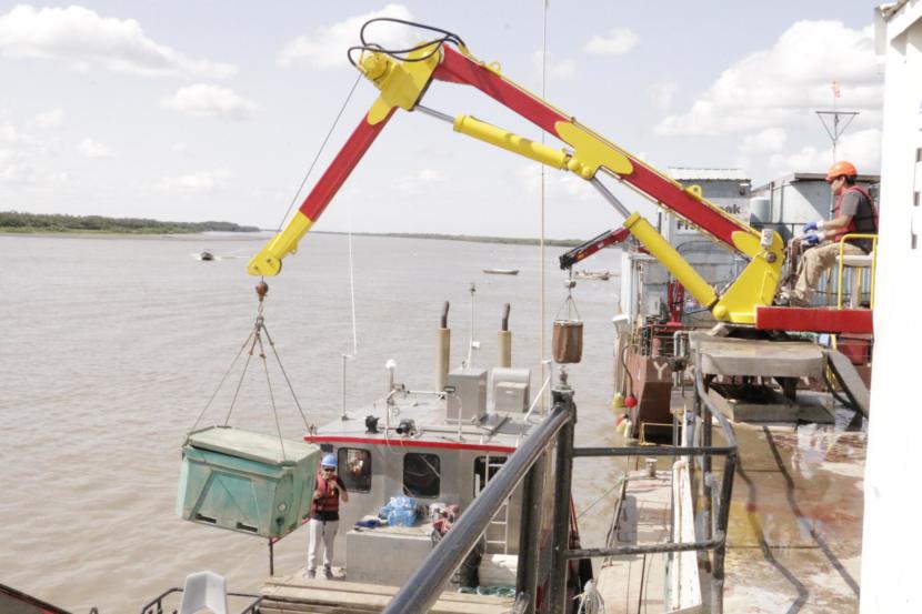 A crane unloads totes of salmon from a tender at Kwik'Pak Fisheries in Emmonak, Alaska on July 15, 2019. (Photo by Anna Rose MacArthur/KYUK)