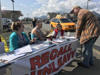 Recall Dunleavy volunteers Frankie Urquhart, left, Jessie Chapman and Pat Chapman gather signatures on Aug. 1 in downtown Ketchikan for a petition to remove Gov. Mike Dunleavy from office. (Photo by Elizabeth Gabriel/KRBD)