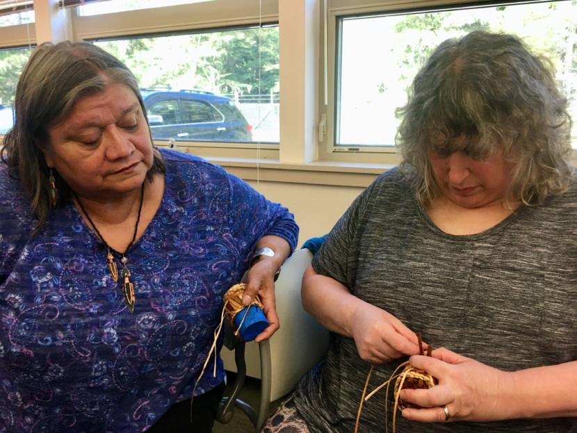 Holly Churchill (left) looks on as Brita Steinberger works on a basket during a Sealaska Heritage Institute seminar for teachers on Northwest Coast arts and math on Aug. 8, 2019. (Photo by Zoe Grueskin/KTOO)