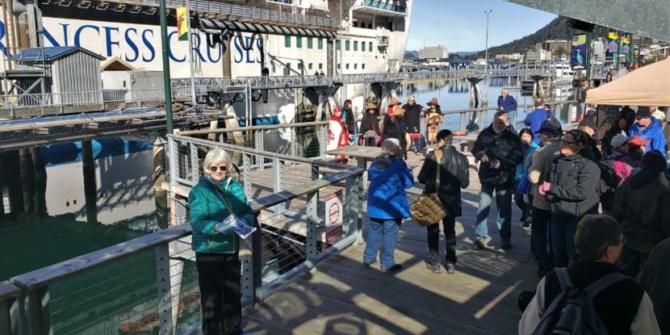 Vicki Logan of Travel Juneau greets and hands out walking maps to passengers of the Ruby Princess at the Franklin Dock on Sunday, April 28, 2019. (Photo by Jeremy Hsieh/KTOO)