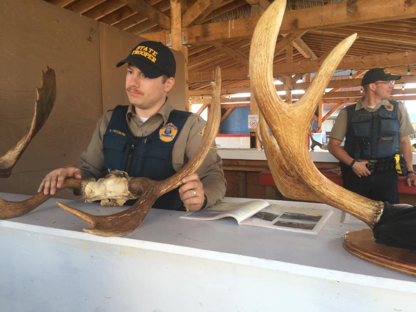 Alaska Wildlife Troopers Kyle Freeberg (left) and Cody Lister (right) tell hunters in Wrangell what they need to know about the nuanced antler restrictions for the month-long moose hunt.