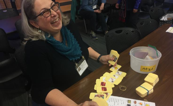 Lingít learner Barbara Craver displays a Lingít language learning game modeled on "go fish." She and others played the game before the 4th International Lingít Spelling Bee in Juneau on Sep. 27, 2019. (Photo by Zoe Grueskin/KTOO)