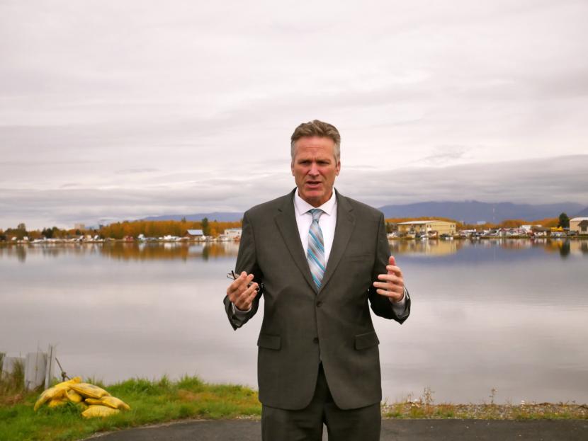 Gov. Mike Dunleavy addresses reporters on the bank of Lake Hood after touring cargo operations at Ted Stevens Anchorage International Airport.