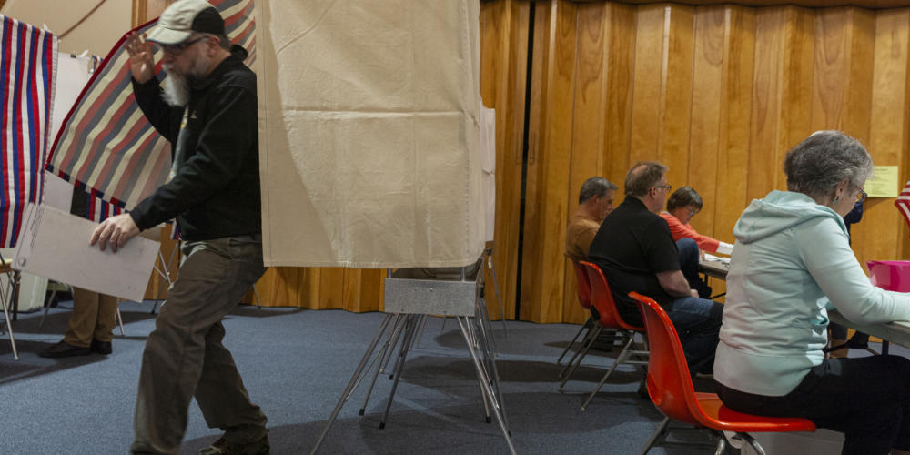 A voter leaves the booth as election workers at Northern Light United Church assist other voters during Municipal Elections on October 1, 2019, in Juneau, Alaska. (Photo by Rashah McChesney/KTOO)