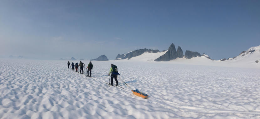 Juneau Icefield Research Program (JIRP) students during a four day and 83 kilometer ski traverse across Taku Glacier in 2019, carrying all their food, water, clothing, tents, and science gear as they help measure the mass balance along the way. (Photo courtesy of Christopher McNeil/USGS)