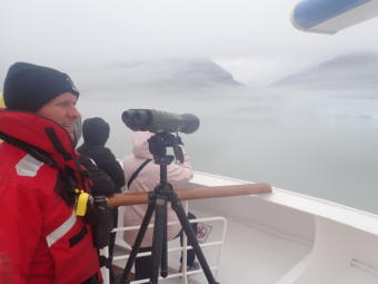National Park Service scientist Scott Gende spots for whales and logs their behavior from the deck of the Noordam in Glacier Bay, Alaska. The cruise line has been providing space for federal whale observers in the national park since 2006. (Photo by Jacob Resneck/Coast Alaska)