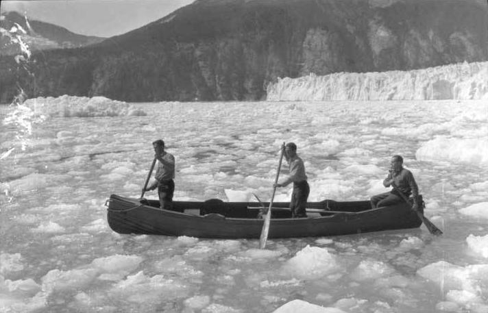 Three men paddling canoe in ice before Taku Glacier. Left to right: Ben Wood, W. O. Field and Roscoe Bonsal. (P87-1981 Alaska State Library - Winter and Pond Photo Collection)