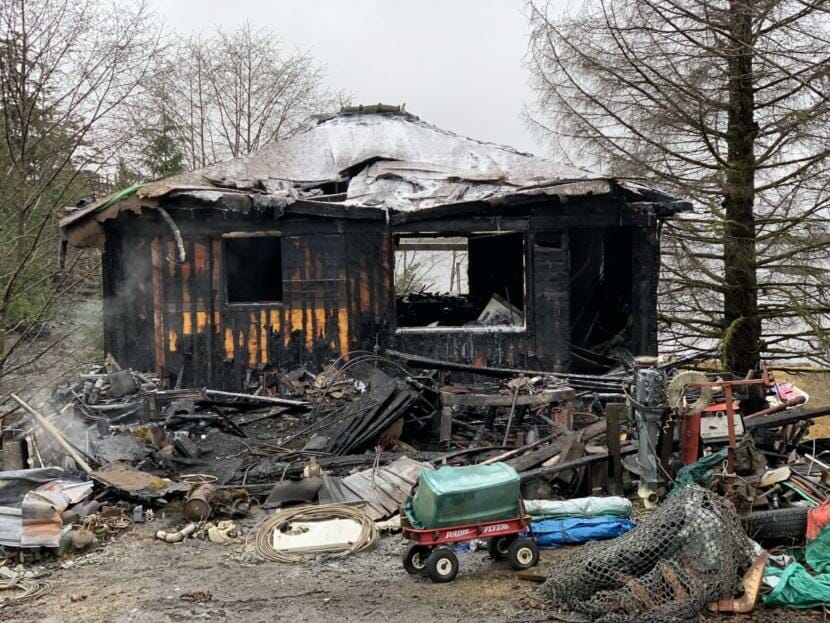 A small house smolders after burning in a fire.