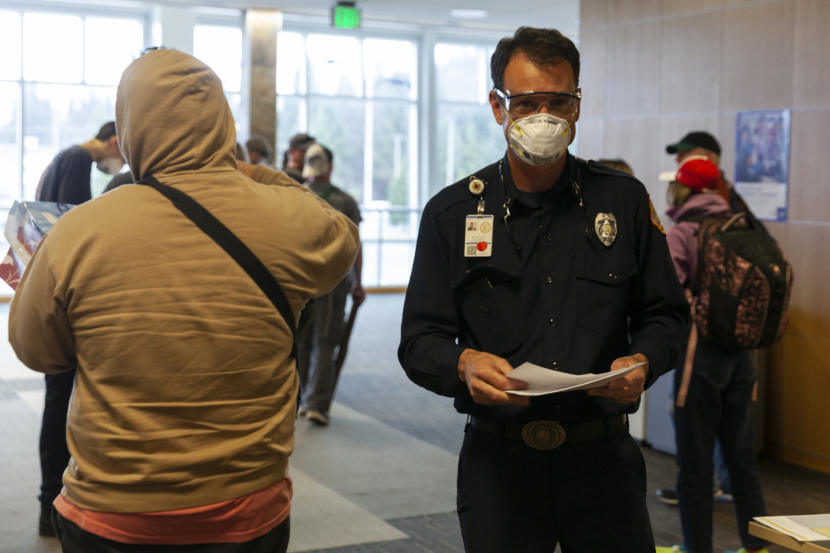 Capital City Fire and Rescue Capt. Roy Johnston talks to people arriving at Juneau International Airport on Saturday, March 21, 2020 in Juneau,