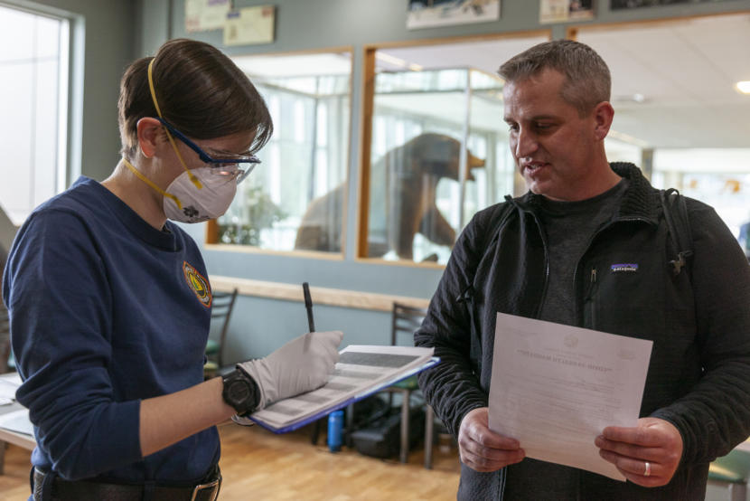 Lily Kincaid asks Richard Clarke questions about where he traveled and who he was with before taking his temperature on Saturday, March 21, 2020 in Juneau, Alaska.