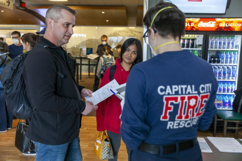 Richard Clarke, left, and Namfon Noisai answer screening questions after landing at Juneau International Airport on Saturday, March 21, 2020 in Juneau,