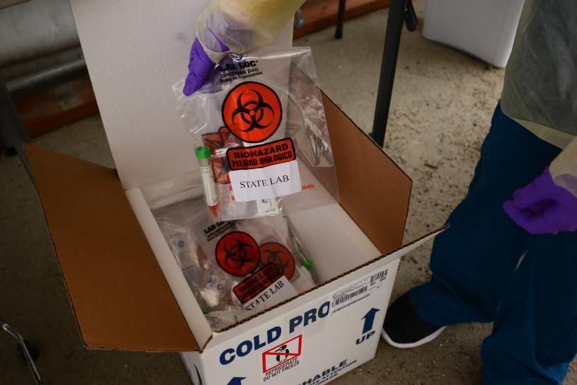 A clinician pulls a sterile COVID-19 screening kit from a box at SEARHC’s drive-up clinic in Sitka on Friday, March 20, 2020. (KCAW photo/Berett Wilber)