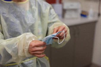 Katie Church, an RN at Bartlett Regional Hospital, demonstrates putting on personal protective equipment to handle a patient infected with COVID-19 on Monday, April 7, 2020 in Juneau, Alaska. (Photo by Rashah McChesney/KTOO)