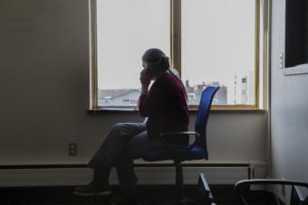 Anchorage School District nurse Elida Spiro sits in an empty room at the Anchorage Health Department Tuesday, March 31, 2020 as she makes contact with a person that has been quarantined due to possible exposure to Covid-19. (Photo courtesy Robert DeBerry/Anchorage School District)