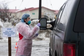 Registered Nurse Avelina Chung runs through protocol with a YKHC employee at the COVID-19 drive-thru test site on March 25, 2020 in Bethel, Alaska. Credit Katie Basile / KYUK