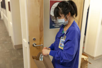 Katie Church, an RN at Bartlett Regional Hospital, demonstrates putting on personal protective equipment to handle a patient infected with COVID-19 on April 7, 2020 in Juneau. The state's Chief Medical Officer Dr. Anne Zink said Friday that most medical facilities in Alaska were well provisioned with personal protective equipment. (Photo by Rashah McChesney/KTOO)