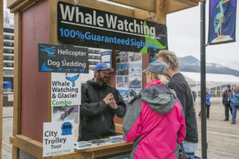 Cruise ship passengers look to book a whale watching trip on Juneau's docks. The cruise season will be severely curtailed in 2020 due to the COVID-19 pandemic, that's leaving many small businesses in financially precarious positions. (Annie Bartholomew / KTOO)