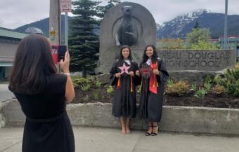Maya Araujo, left and Jade Araujo pose for graduation photos outside Juneau-Douglas High School: Yadaa.at Kale on May 18, 2020.