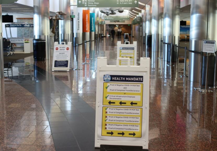 Signs at the Ted Stevens Anchorage International Airport direct travelers where to go depending whether they have their declaration form filled out and whether they have proof of a negative result from a test for COVID-19. (Tegan Hanlon/Alaska Public Media)