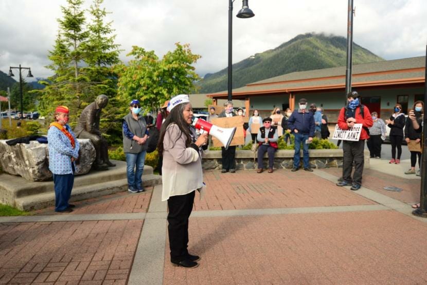 Alaska Native Sisterhood Grand President Paulette Moreno speaks to a crowd gathered around the Alexander Baranov statue in front of Sitka’s Harrigan Centennial Hall on Tuesday. Protesters are asking the city to relocate and replace the monument. (Berett Wilber/KCAW)