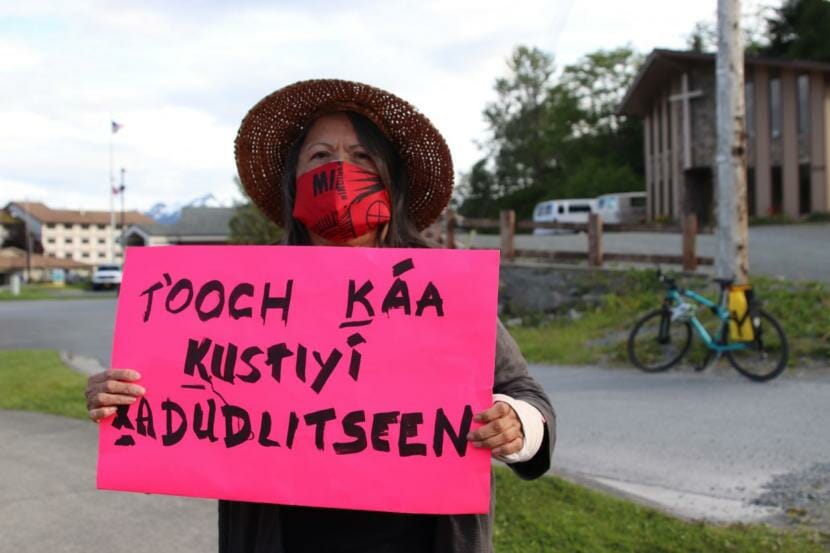 Louise Kh’asheechtlaa Brady holds up a sign written in Tlingit at a local Black Lives Matter protest in Sitka. She’s in agreement with the calls to “defund” the police and wants to see more funding for social services, mental health care and drug and alcohol treatment instead. (Erin McKinstry/KCAW)