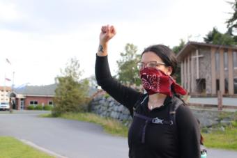 A demonstrator holds up her fist in solidarity with the Black Lives Matter movement at Sitka’s main roundabout. (Erin McKinstry/KCAW)