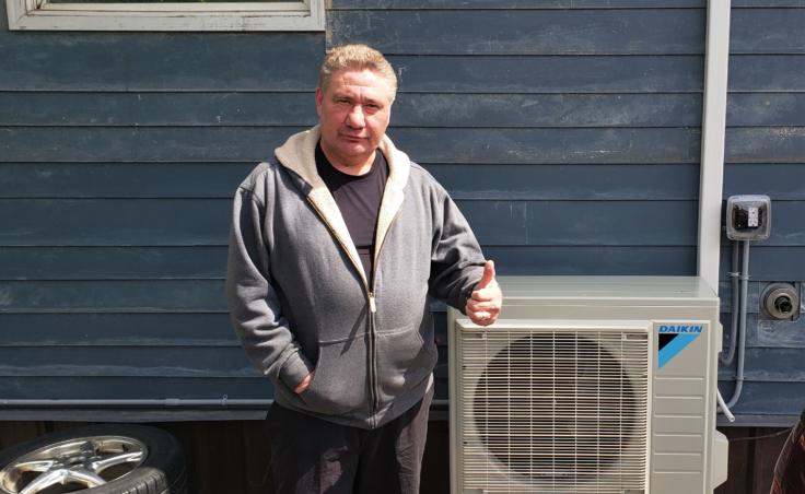 Ray Lindoff poses next to his new air-source heat pump at his home in downtown Juneau on June 5, 2020.