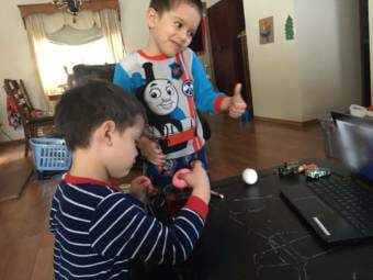 Siblings James Ackerman, left, and Timothy Ackerman, ages 4 and 5, work on Easter eggs at home via distance learning in the spring of 2020.