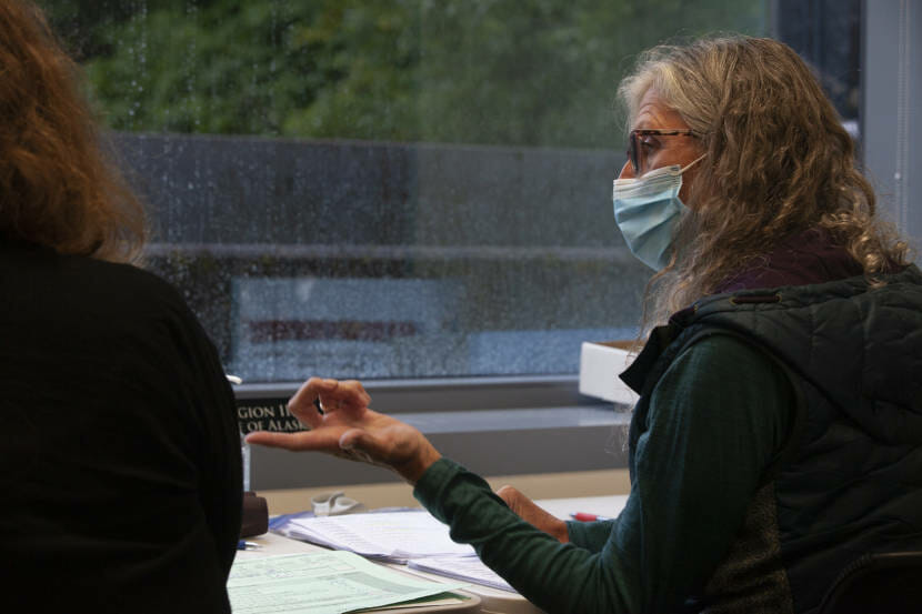 Shelly Mangusso talks to Barbara Sandberg as the two check voter rolls from Region III on Tuesday, August 25, 2020 in Juneau, Alaska. (Photo by Rashah McChesney/KTOO)