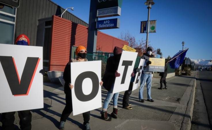 Volunteers and organizers with the Alaska Civic Engagement State (AKCES) Table gather on Election Day 2020 in Mountain View to remind residents to vote. AKCES is a nonpartisan group with 75 volunteers that have been showing up at the polls to support voter education and safety. (Jeff Chen/Alaska Public Media)