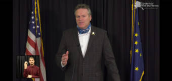 Alaska Gov. Mike Dunleavy appeals to Alaskans to support neighbors, businesses and charities affected by COVID-19 this holiday season. He made the appeal during a news conference, Dec. 15, 2020. A sign language interpreter is on the lower left. (Screen capture of news conference)