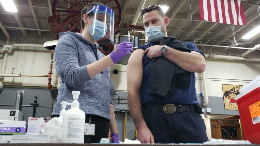 Capital City Fire/Rescue paramedic Lily Kincaid asks Capt. Trevor Richards to verify that there is .3 milliliters of fluid in the syringe with Pfizer's COVID-19 vaccine at the downtown fire station in Juneau on Dec. 17, 2020.