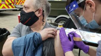 Capital City Fire/Rescue paramedic Lily Kincaid injects firefighter/EMT Mark Fuette with Pfizer's COVID-19 vaccine at the downtown fire station in Juneau on Dec .17, 2020.