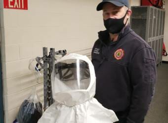 Capital City Fire/Rescue firefighter/paramedic Paul Hammerquist holds a positive air flow respirator, or PAPR, that he wears on certain calls at the downtown fire station in Juneau on Dec. 17, 2020.
