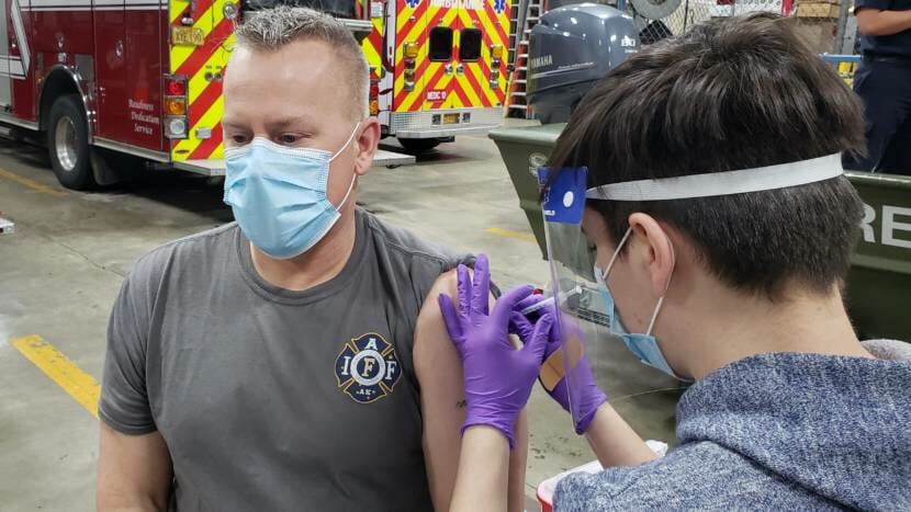 Capital City Fire/Rescue paramedic Lily Kincaid injects firefighter/EMT Pete Ostman with a dose of Pfizer's COVID-19 vaccine at the downtown station in Juneau on Dec. 17, 2020.