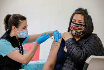Anchorage Health Department public health nurse Molly Carver administers the Covid-19 vaccine to Malia Tuga at the community vaccine clinic held at Manai Fou Assembly of God Church in Airport Heights on Feb. 23, 2021. (Jeff Chen/Alaska Public Media)