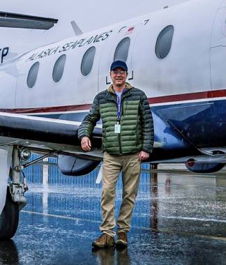 Andy Kline poses in front of an airplane. Kline is the marketing manager for Alaska Seaplanes.