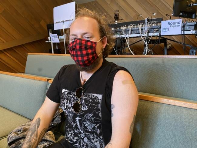 Axel Gillam sits in the pews of Resurrection Lutheran Church during a pop-up vaccine clinic event.