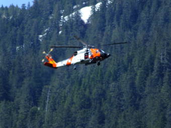 A Coast Guard helicopter hovers over Switzer Creek where the search continues for Geraldine Nelson on Wednesday, May 19, 2021 in Juneau, Alaska. (Photo by Matt Miller/KTOO)