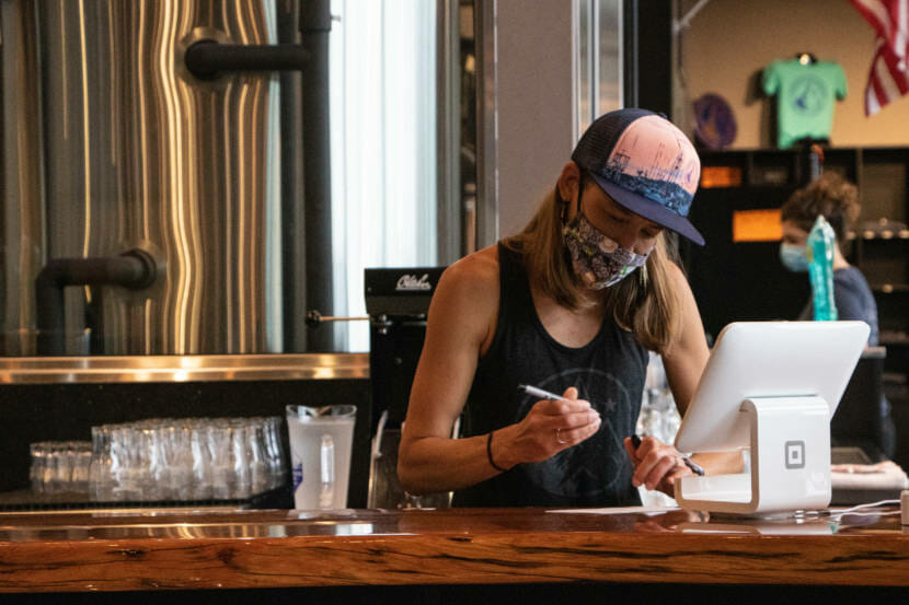 Sara Stekoll works behind the counter at Forbidden Peak Brewery. She is a co-owner of the brewery and asked the City and Borough of Juneau to host a vaccine clinic there.