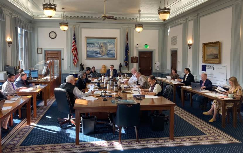 Members of the conference committee on the state budget bills on June 13, 2021, in the Alaska State Capitol in Juneau, Alaska. The bills would fund the budget that begins on July 1, 2021. The members include Reps. Bart LeBon, R-Fairbanks; Kelly Merrick, R-Eagle River; and Neal Foster, D-Nome, seated on the left side of the center table. Sens. Bert Stedman, R-Sitka; Click Bishop, R-Fairbanks; and Donny Olson, D-Golovin, are seated on the left. Chief legislative budget analyst Alexei Painter is seated in the center. Legislative aides are seated around the edges. (Photo by Andrew Kitchenman/KTOO and Alaska Public Media) 