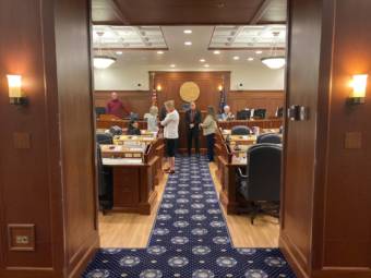 Members of the Alaska House of Representative mill around the front of the House chamber before a brief technical session on Friday, June 22, 2021, in the Alaska State Capitol in Juneau. (Photo by Andrew Kitchenman/KTOO and Alaska Public Media)