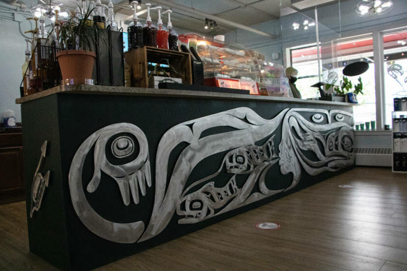 An aluminum carving created by Tlingit artist Robert Mills is mounted below the bar counter at the Sacred Grounds coffee shop in Juneau, Alaska. (Photo by Lyndsey Brollini/KTOO)