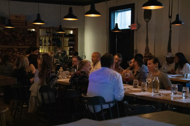 Diners wait for the first course of a six-course meal being served at In Bocca Al Lupo's event "Dinner with Friends: Womxn of Power edition" in Juneau, Alaska. (Photo by Lyndsey Brollini/KTOO)