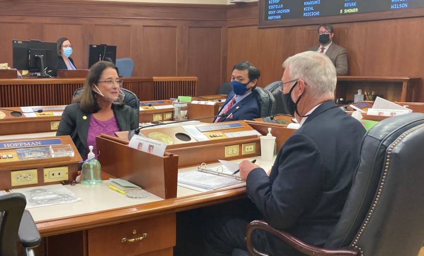 Eagle River Republican Sen. Lor Reinbold, left, talks with Fairbanks Democratic Sen. Scott Kawasaki and Kodiak Republican Sen. Gary Stevens on Sept. 10, 2021, in the Alaska State Capitol in Juneau, shortly before the Senate passed a bill aimed at easing the strain on hospitals from the COVID-19 surge. Reinbold proposed two amendments that passed that oppose COVID-19 vaccine mandates. (Photo by Andrew Kitchenman/KTOO and Alaska Public Media)