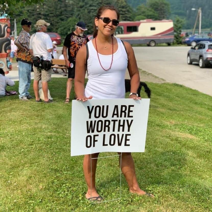 Jaeleen Kookesh poses with a 'you are worthy of love sign' provided by the Find Your Fire organization. 