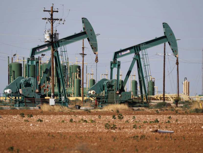 A green pump jack in a Texas oilfield